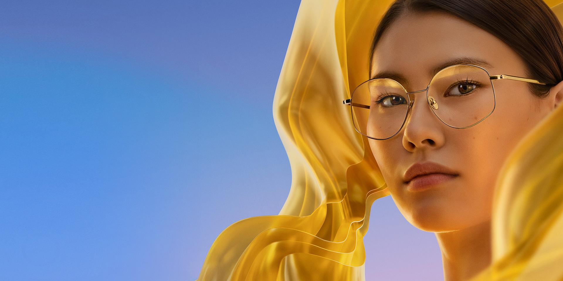 Mulher a usar óculos incolores com ZEISS DuraVision Gold UV, que confere à lente um reflexo dourado subtil, porém distinto.