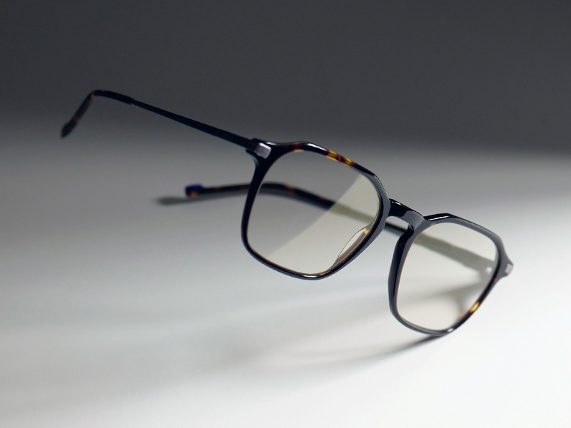 Imagem de lentes incolores com a subtil tonalidade dourada do ZEISS DuraVision Gold UV, numas armações castanhas.
