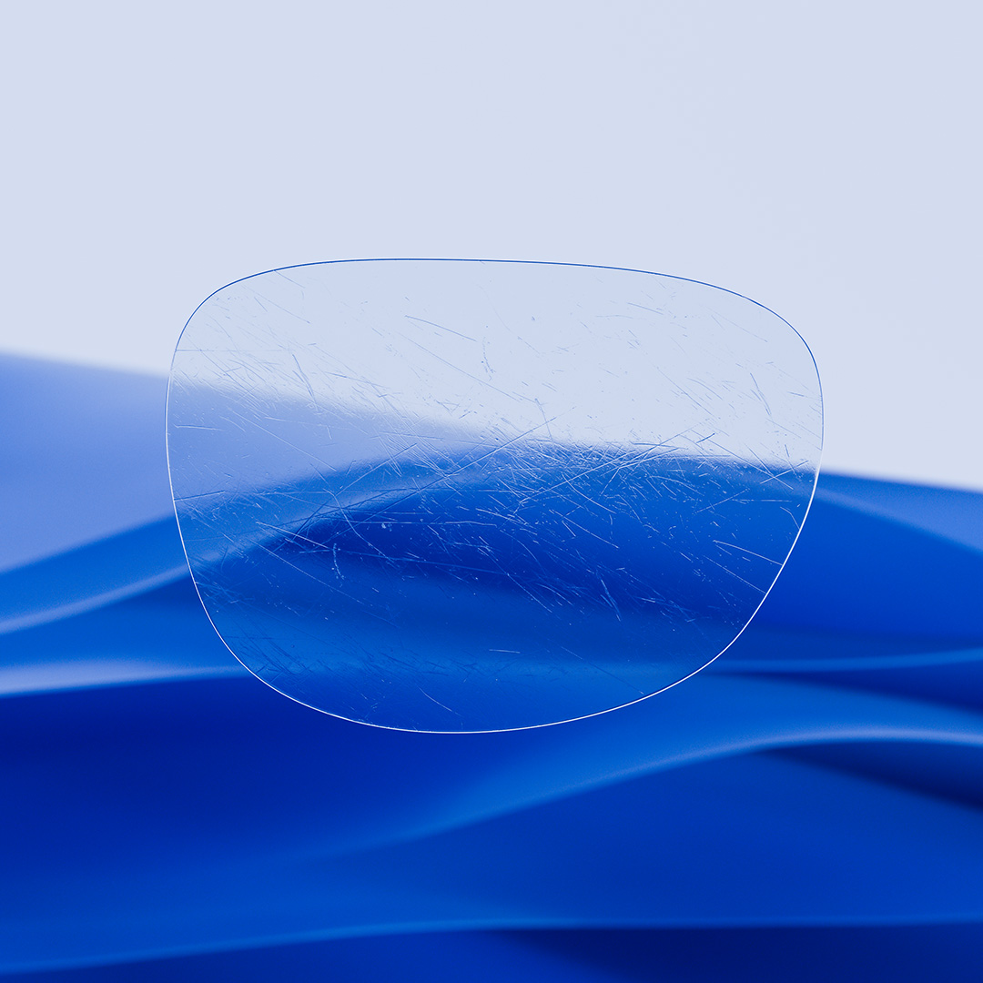Uma lente dividida ao meio, com um lado nítido e limpo com ZEISS DuraVision e um lado coberto de riscos.
