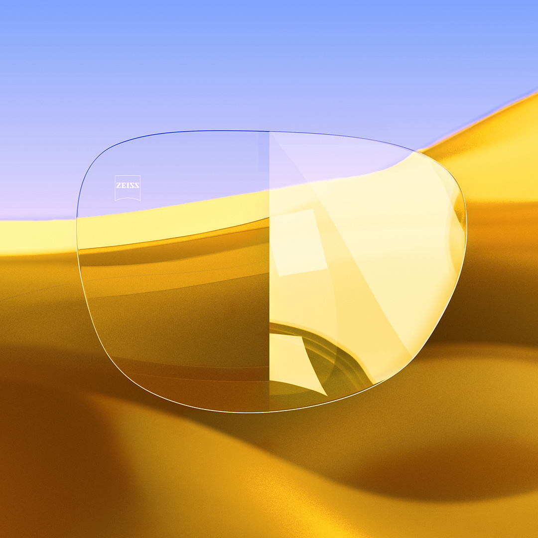 Uma lente dividida ao meio, com um lado nítido e limpo com ZEISS DuraVision Gold UV e um lado com a incidência de reflexos intensos. 