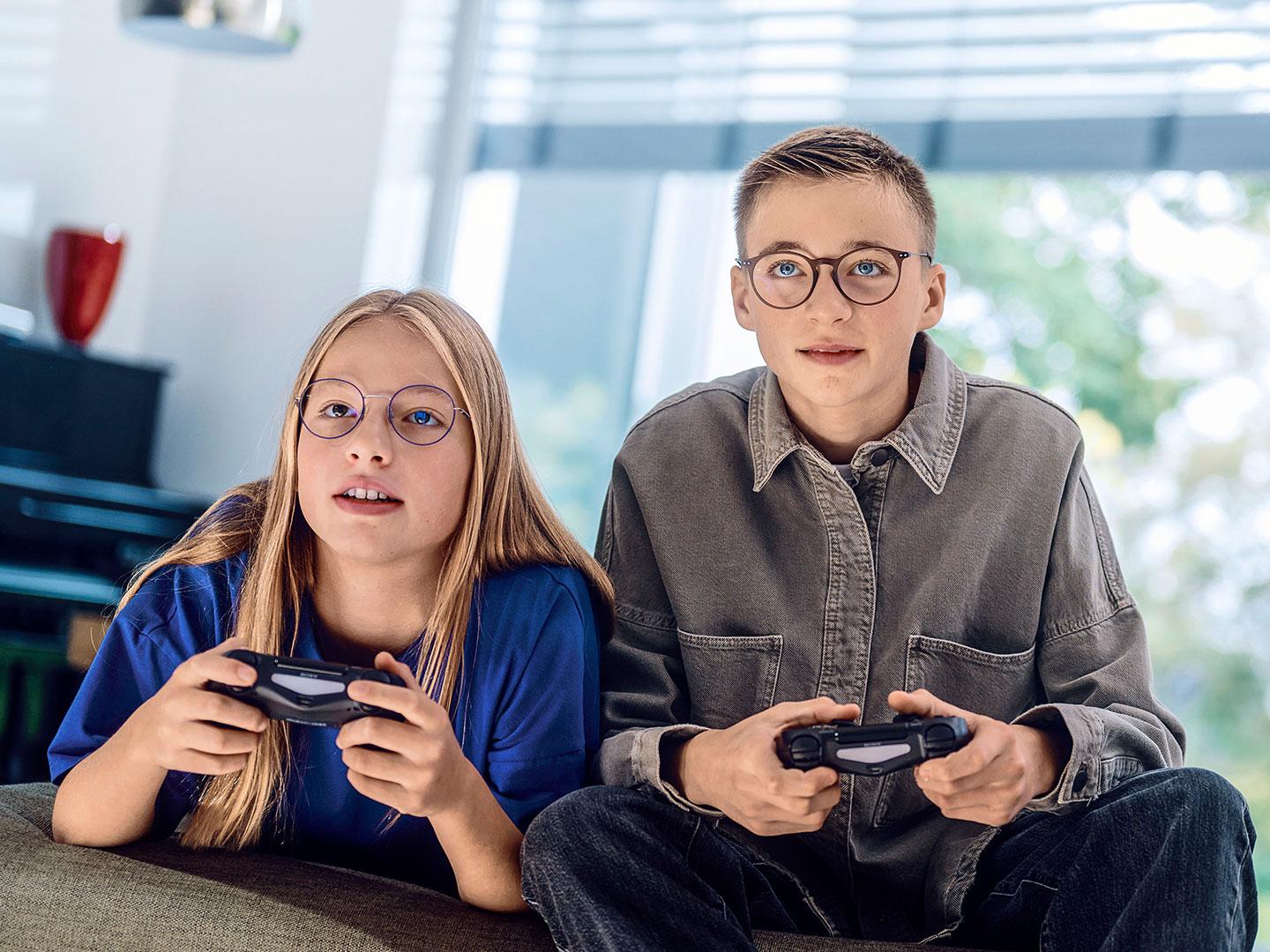 Um casal de adolescentes a jogar jogos de vídeo numa consola.
