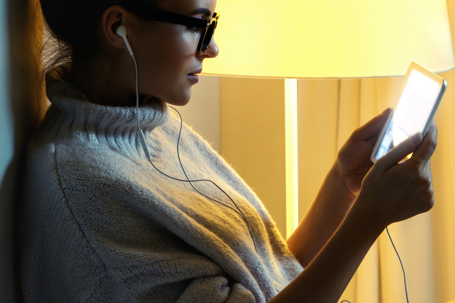 Mulher jovem com uma camisola quente a usar um tablet
