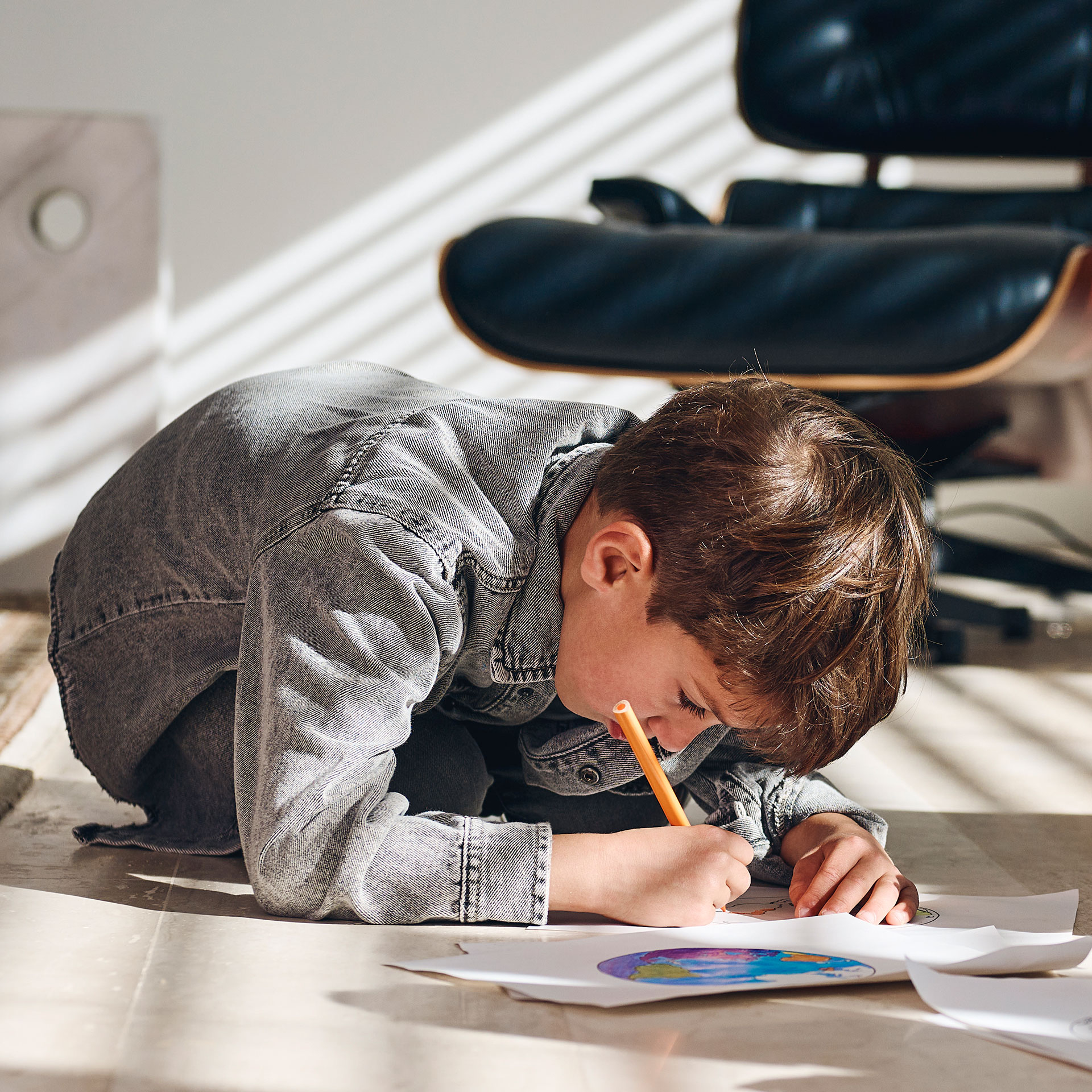 Menino a pintar com a cara muito perto do papel