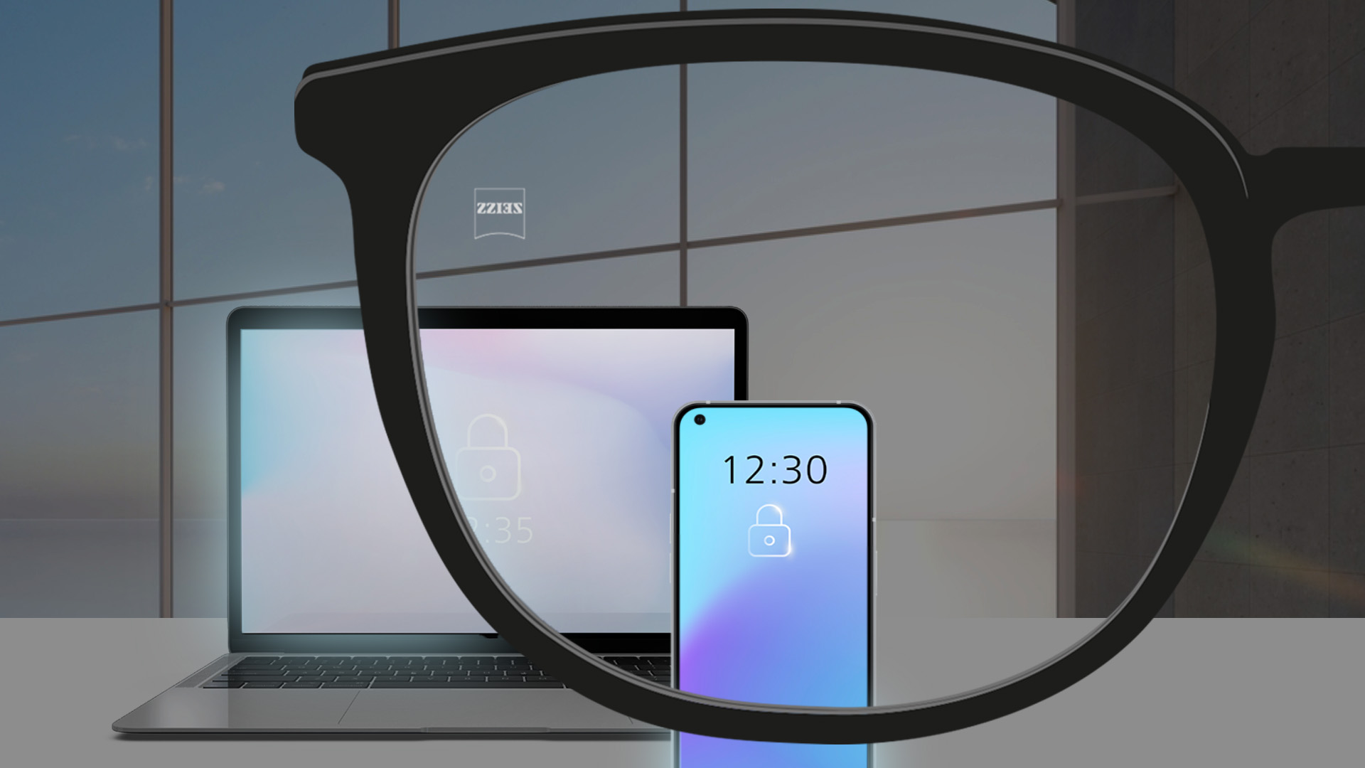 Imagem através de uma lente de um computador portátil e um smartphone numa sala com pouca luz.