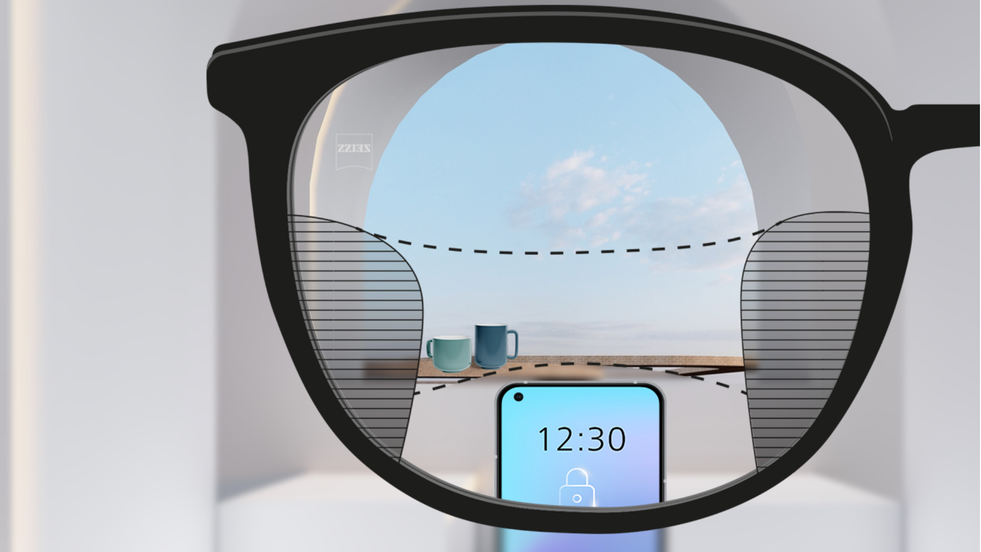 Imagem de um smartphone e de chávenas em segundo plano através da lente ZEISS SmartLife Progressiva, que está totalmente nítida, mas com finas parcelas desfocadas à esquerda e à direita.