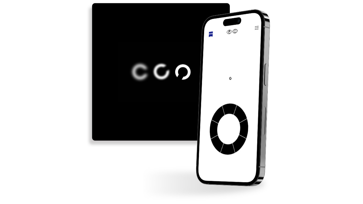 Um smartphone cujo ecrã apresenta um exercício do teste de visão online da ZEISS, em frente a um botão quadrado preto que mostra círculos com aberturas voltadas para direções diferentes, habitualmente utilizados em testes de visão.