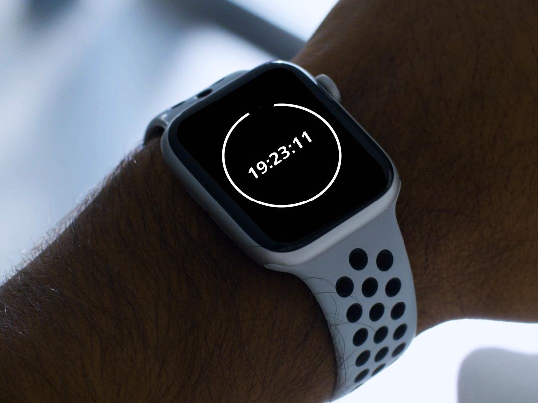 Um jovem com óculos BlueGuard, a olhar para o seu smartwatch que mostra uma contagem decrescente de 20 minutos.  