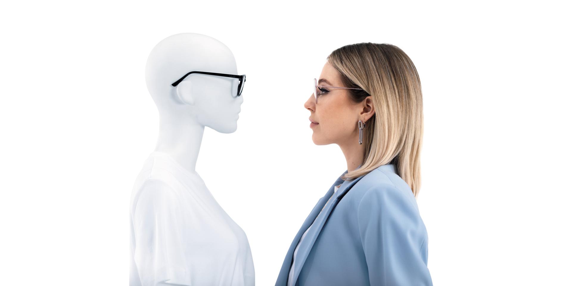 Mulher com óculos ZEISS ClearView a olhar de frente para um manequim com óculos.