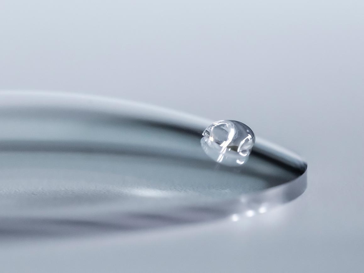 Uma gota de água desliza por uma lente ZEISS com revestimento fácil de limpar.