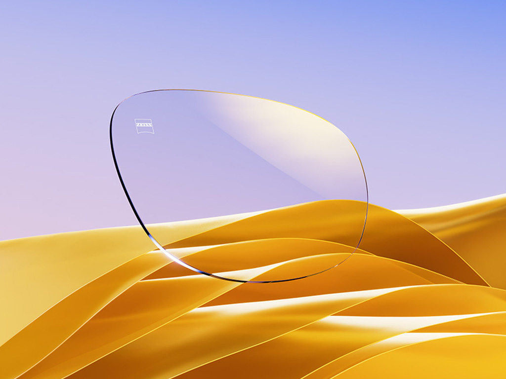 Imagem gerada por computador de uma lente oftálmica transparente com um subtil reflexo dourado.