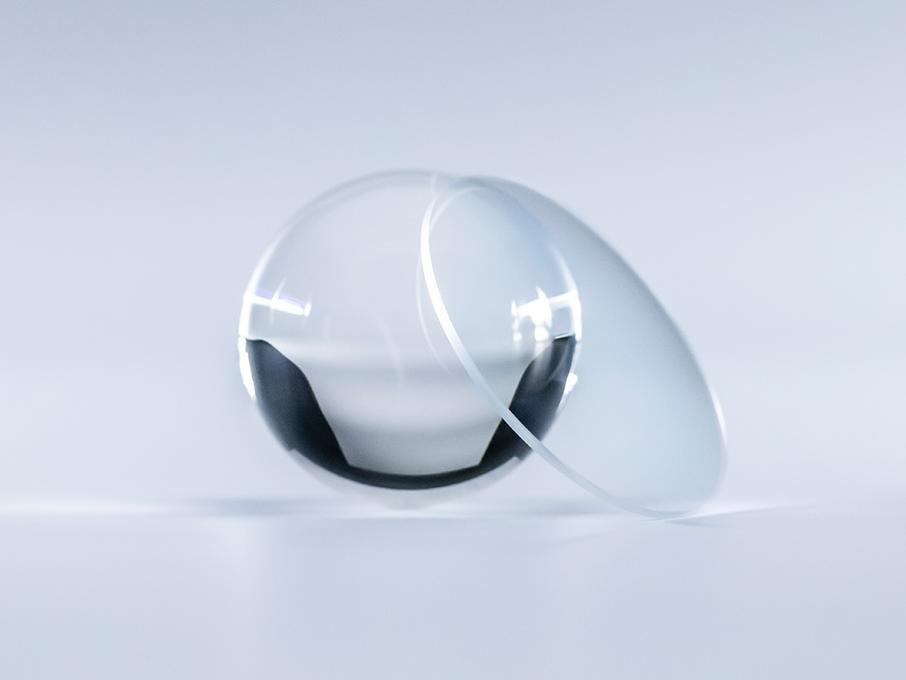 Uma lente com revestimento ZEISS Platinum está límpida e sem reflexos, em comparação com a bola de cristal que se encontra ao seu lado.