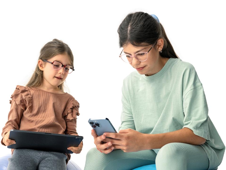 Duas raparigas a olhar para dispositivos digitais à distância sugerida de mais de 20 cm.