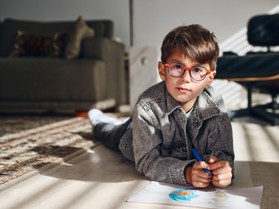 Menino com lentes ZEISS MyoCare a olhar diretamente para a câmara.
