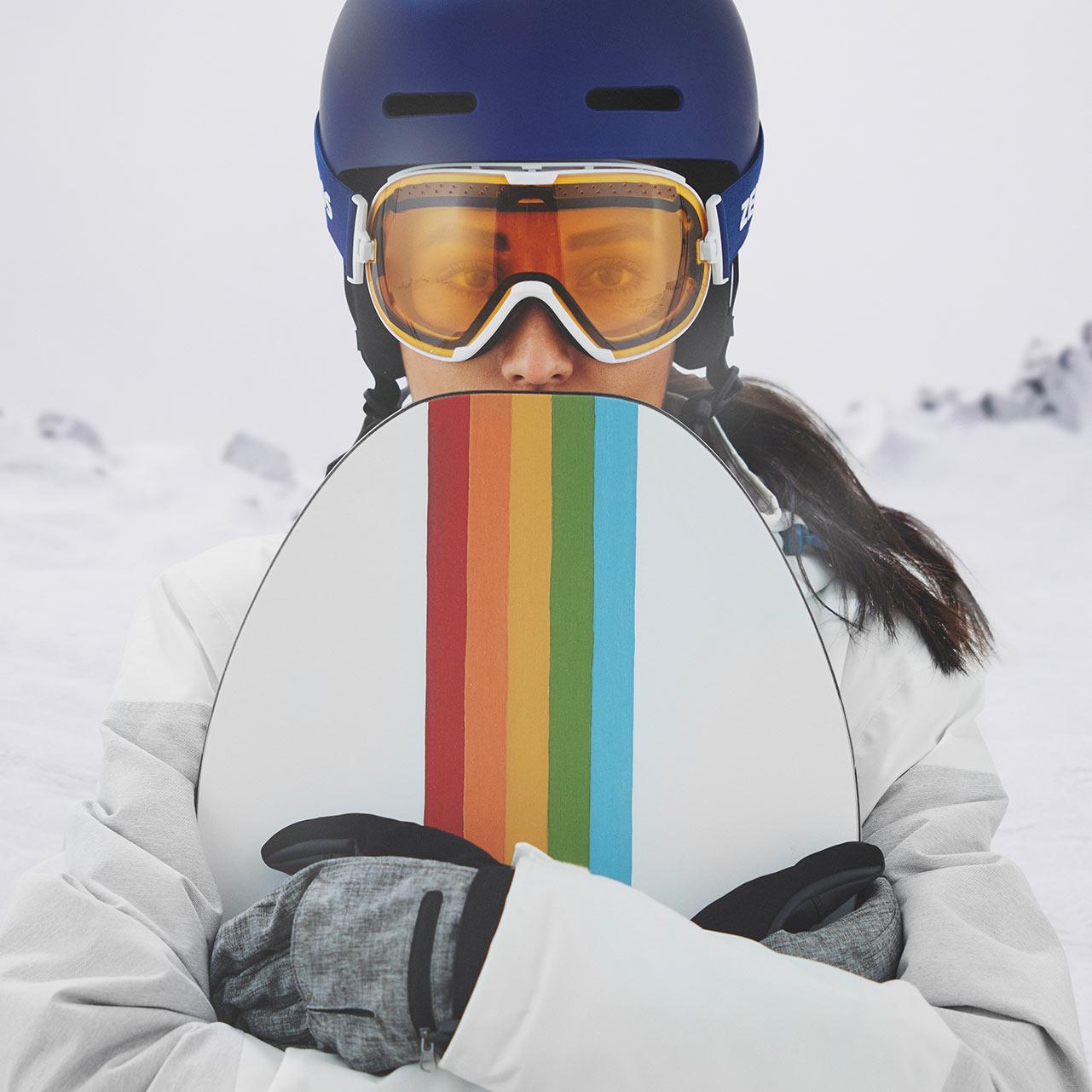 Mulher com capacete azul e máscara ZEISS para a neve com viseira transparente.