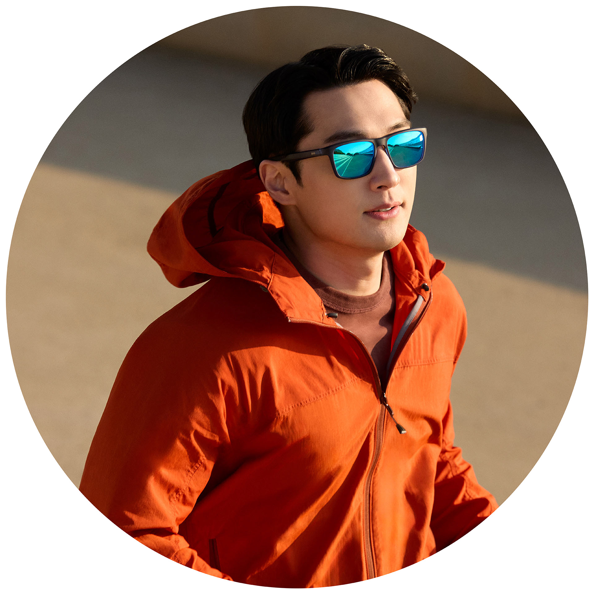 Praticante de jogging com casaco laranja e óculos de sol graduados ZEISS com tratamento espelhado azul.