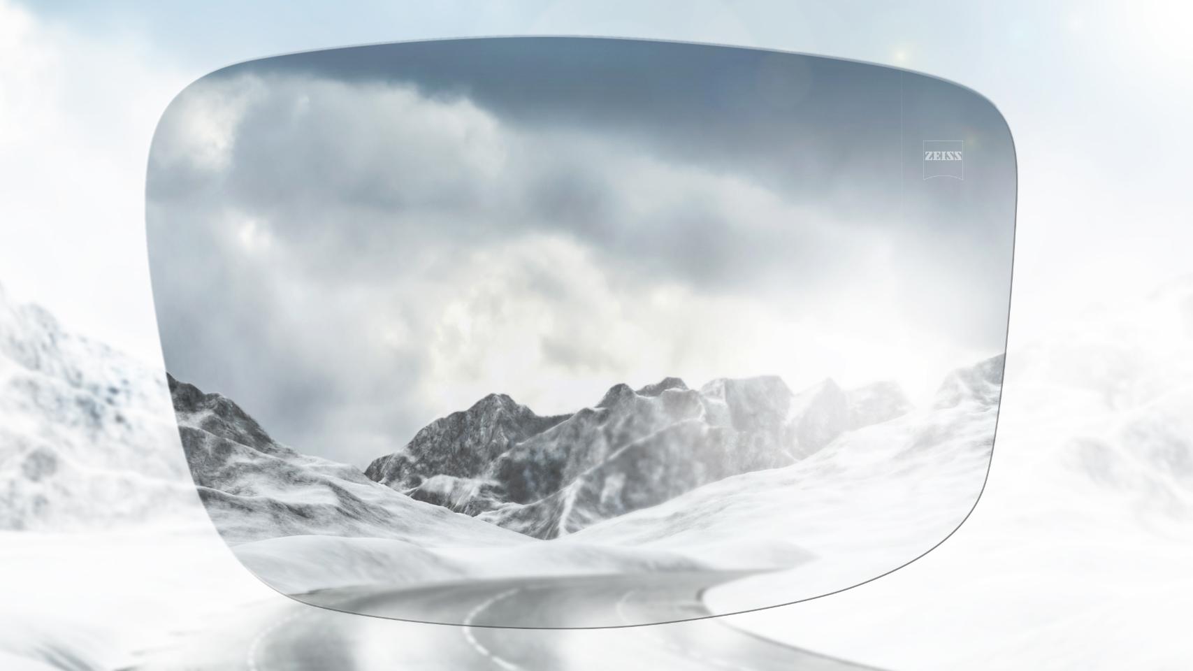 Comparação de uma estrada de montanha com neve com e sem óculos polarizados. Os óculos de sol polarizados reduzem o encandeamento e facilitam a visão em frente.