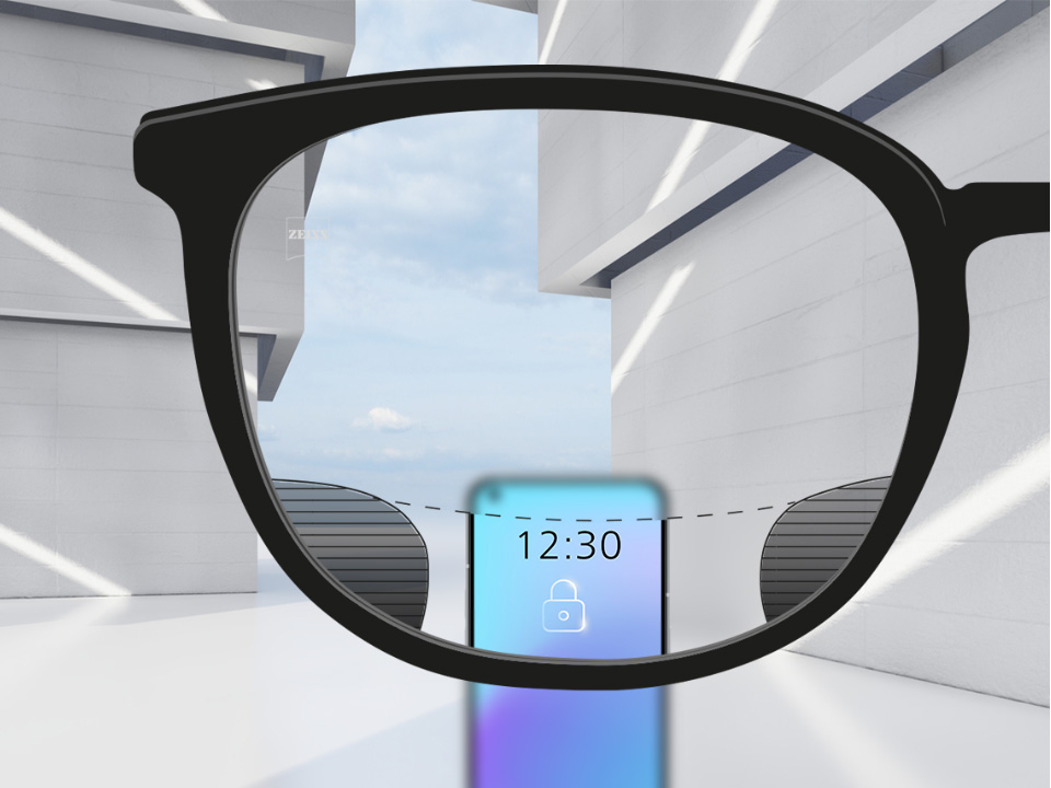 Imagem que mostra um smartphone através da lente ZEISS SmartLife Digital que está totalmente nítida na zona superior e inferior, mas com pequenas parcelas desfocadas à esquerda e à direita. 
