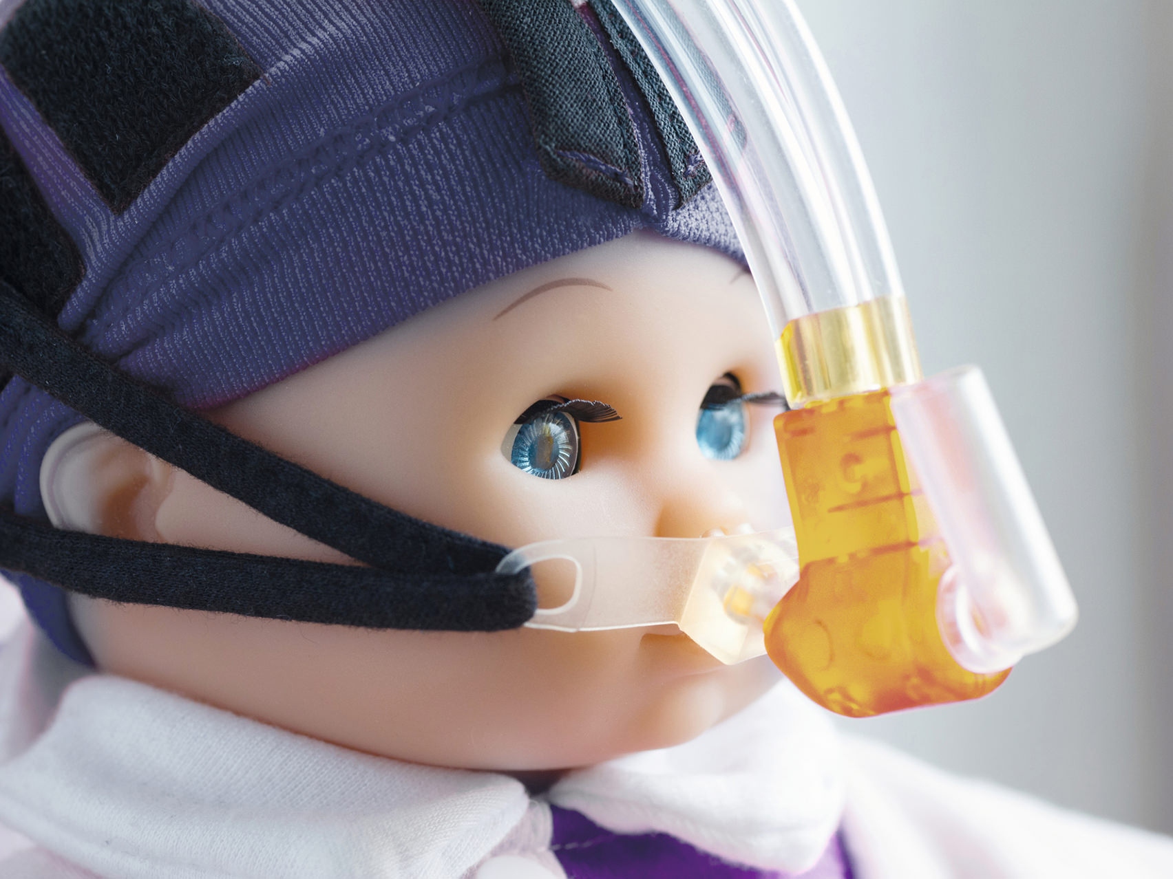 Vista ampliada do rosto de uma boneca a usar uma máscara respiratória.