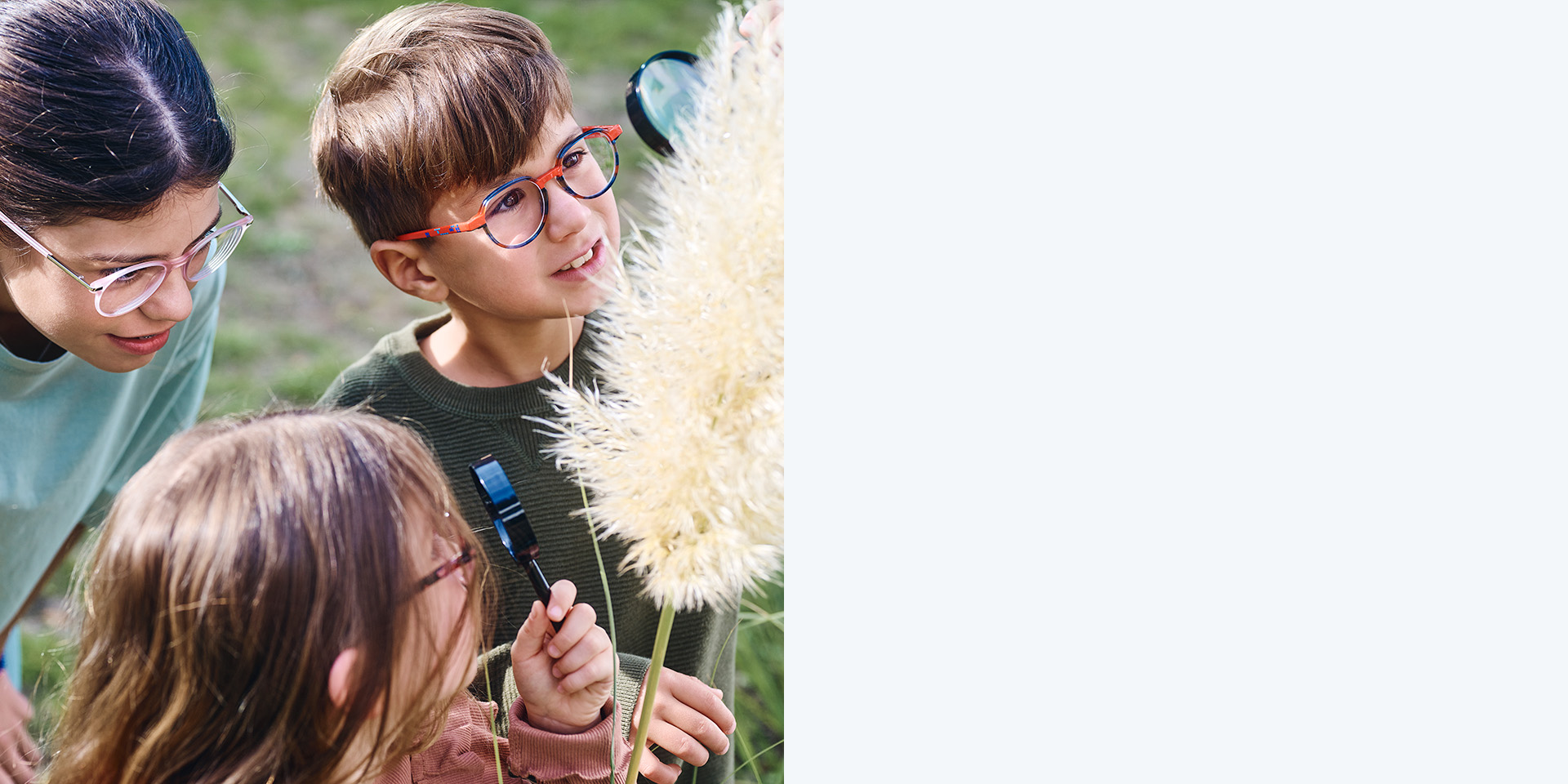 2 meninas e 1 menino a usar lentes ZEISS MyoCare. Eles estão a olhar para uma planta, duas das três crianças estão a olhar para a planta através de lupas.