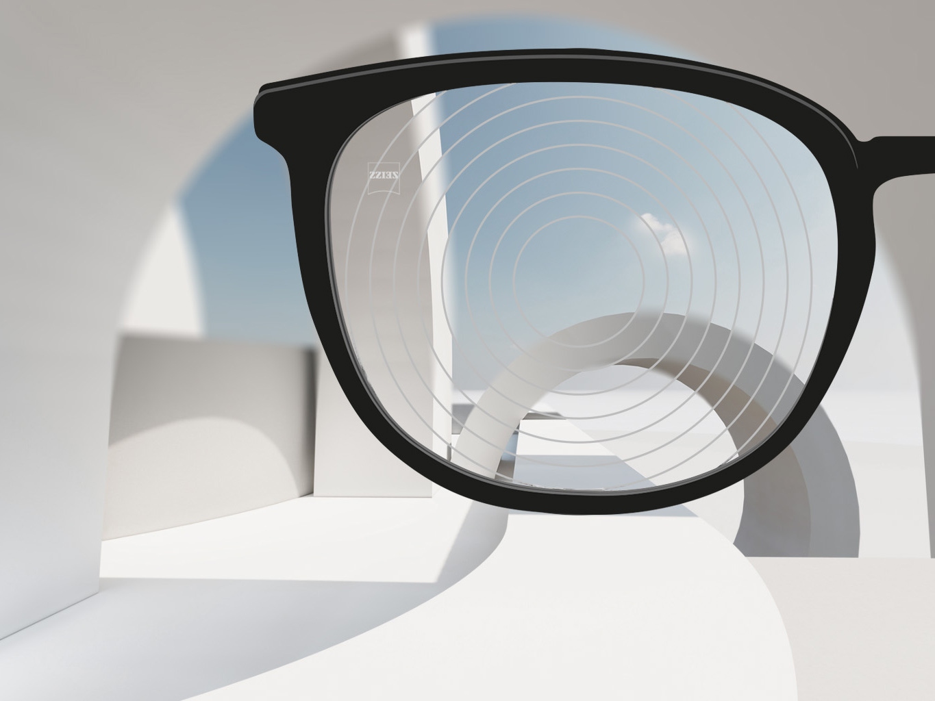 Uma imagem em grande plano das lentes de gestão de miopia ZEISS, com armações de óculos pretas e círculos concêntricos na superfície da lente. 