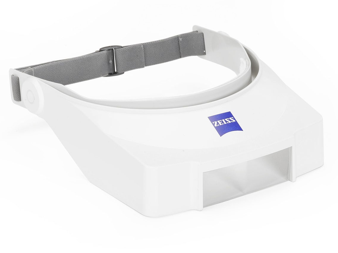 Head-worn loupe with adjustable lace. The magnifier is embedded in a visor of white plastic.